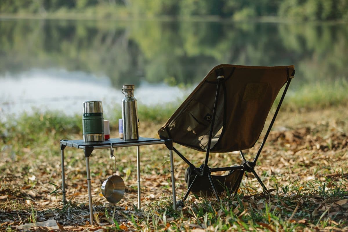 A packable camp chair and table by a lake